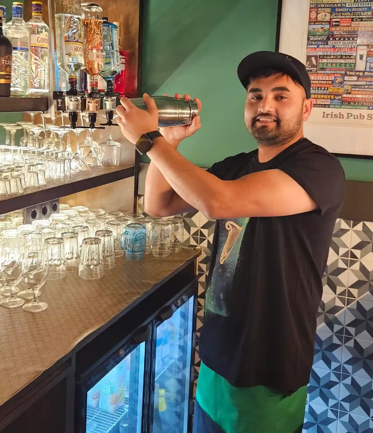 Bartender preparing a cocktail behind the bar at Brady’s Irish Bar