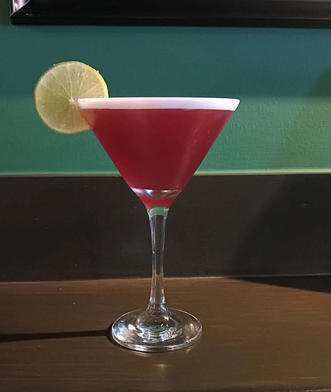 Red cocktail served in a martini glass with lime at Brady’s Irish Bar in Carvoeiro